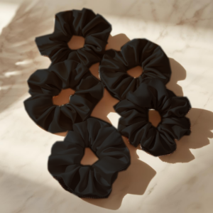 Satijnen scrunchie in rosé, zwart en wit – voorkomt pluis en haarbreuk, ideaal voor krullen en luxe haarverzorging.