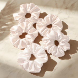 Satijnen scrunchie in rosé, zwart en wit – voorkomt pluis en haarbreuk, ideaal voor krullen en luxe haarverzorging.